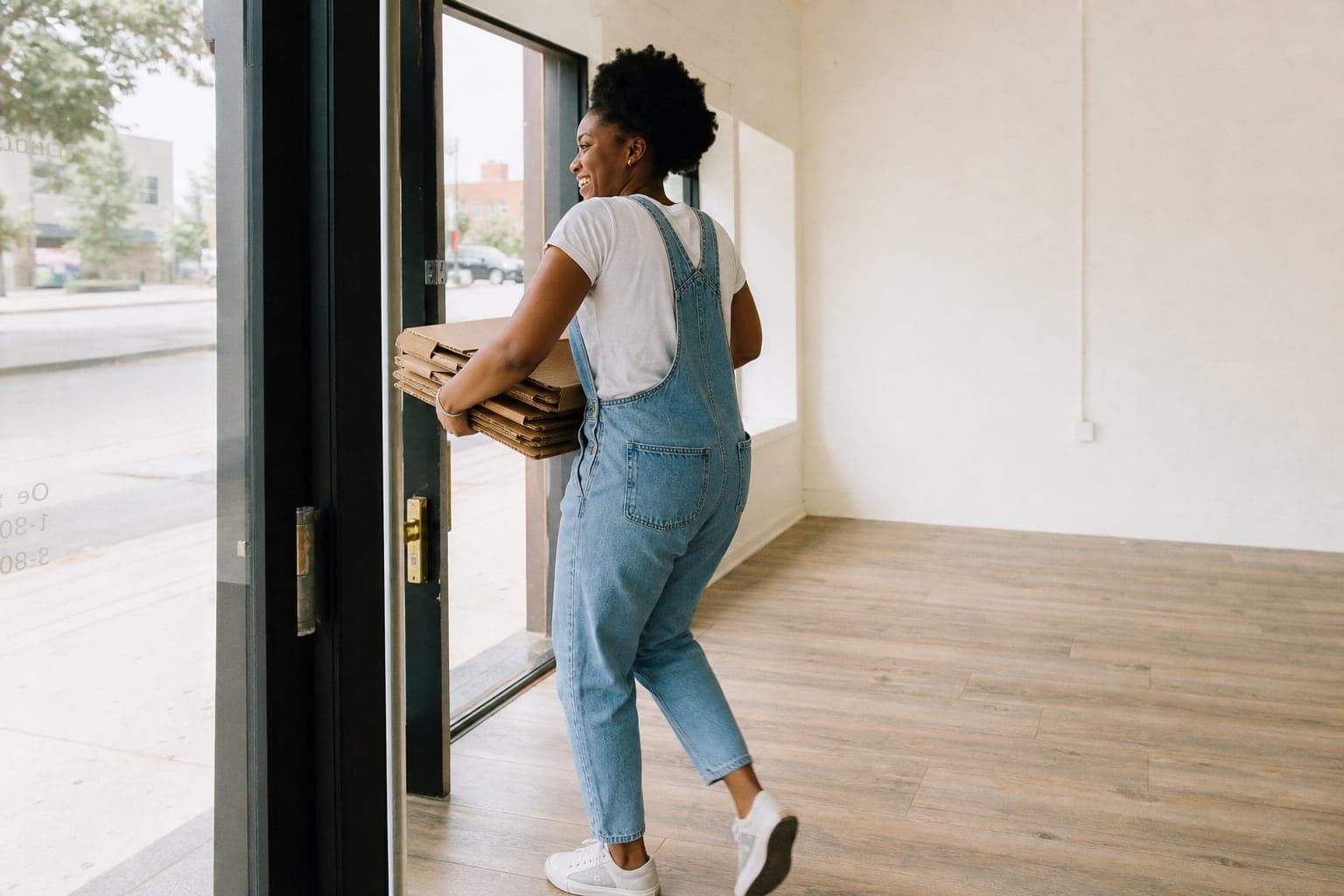 A business owner carrying supplies into a new storefront
